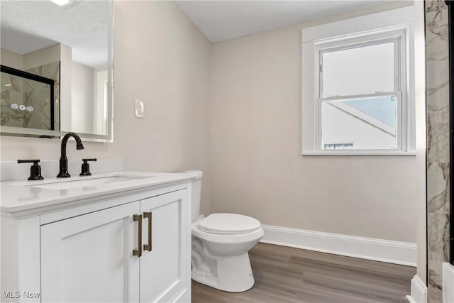 bathroom featuring hardwood / wood-style flooring, an enclosed shower, vanity, and a healthy amount of sunlight