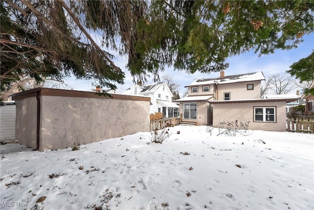 view of snow covered back of property