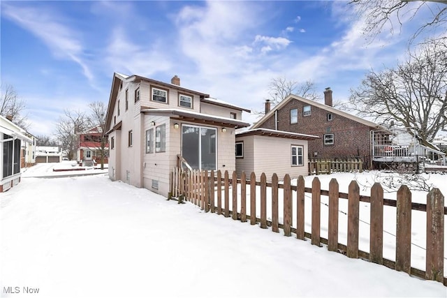 view of snow covered rear of property