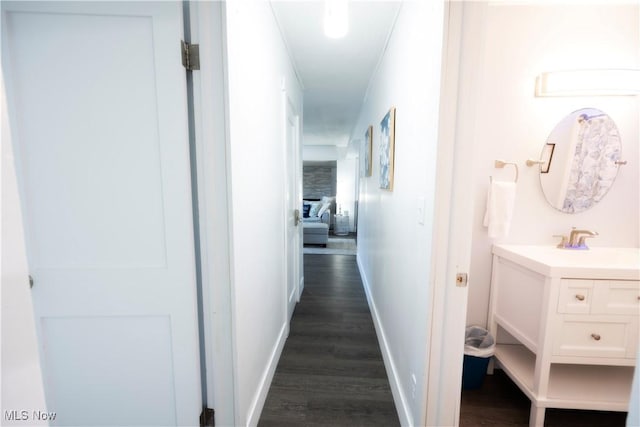 hallway featuring ornamental molding, dark hardwood / wood-style floors, and sink