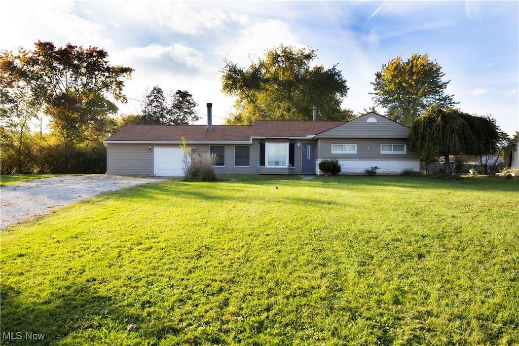 single story home with a garage and a front yard