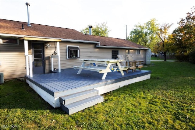 rear view of house featuring a deck and a lawn