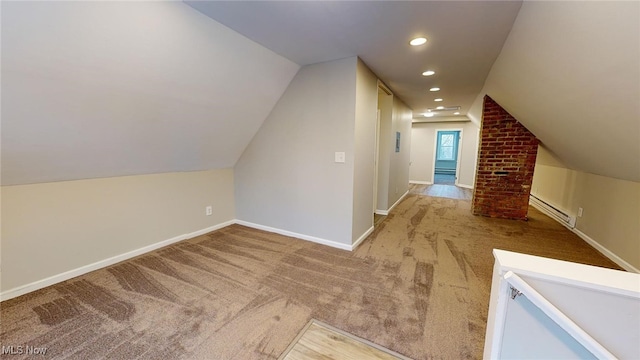 additional living space featuring light carpet, baseboard heating, and lofted ceiling