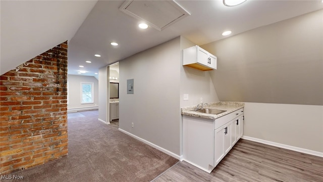 interior space with lofted ceiling, light hardwood / wood-style floors, a baseboard radiator, and sink