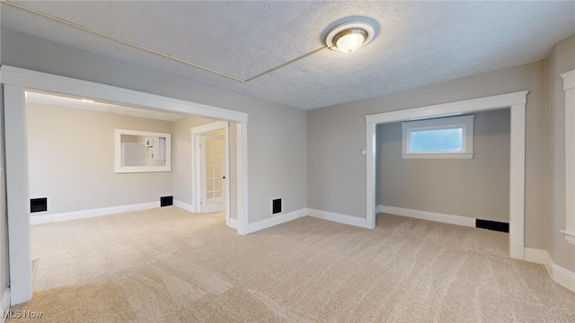 carpeted empty room featuring a textured ceiling