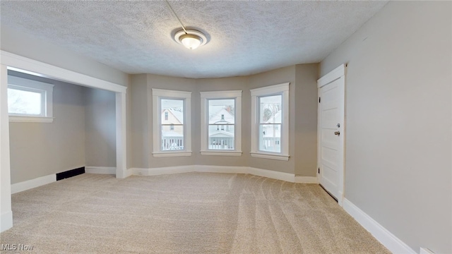 carpeted spare room with a textured ceiling