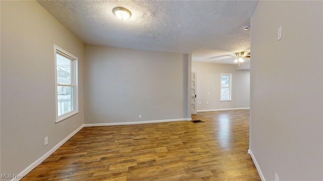 empty room with wood-type flooring and a healthy amount of sunlight