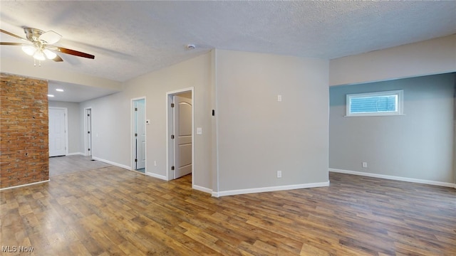 empty room featuring ceiling fan, dark hardwood / wood-style floors, and a textured ceiling