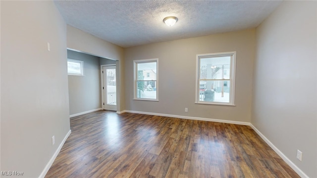 spare room featuring dark hardwood / wood-style floors and a textured ceiling