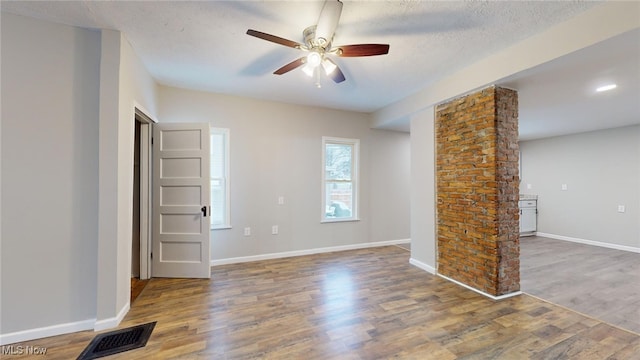 unfurnished room featuring a textured ceiling, ceiling fan, and wood-type flooring