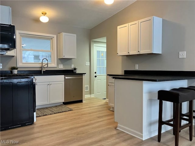 kitchen with sink, white cabinetry, stainless steel dishwasher, and light hardwood / wood-style flooring