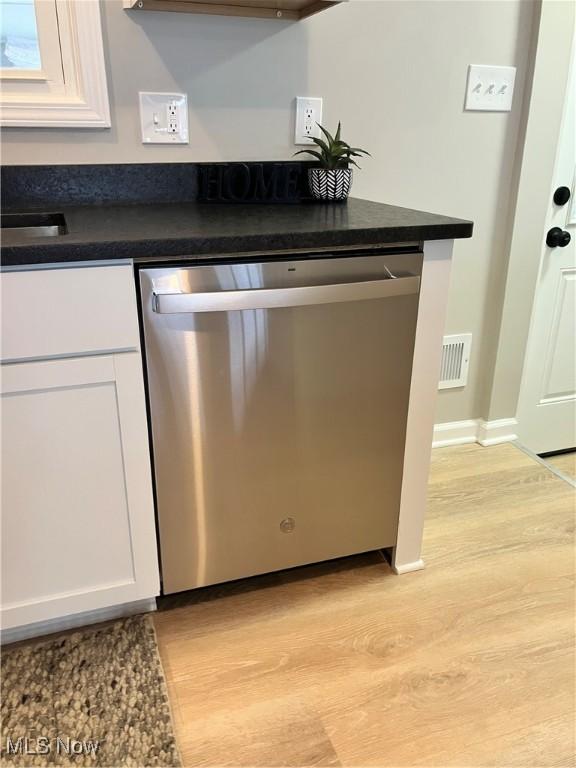 kitchen featuring white cabinets, dishwasher, and light wood-type flooring