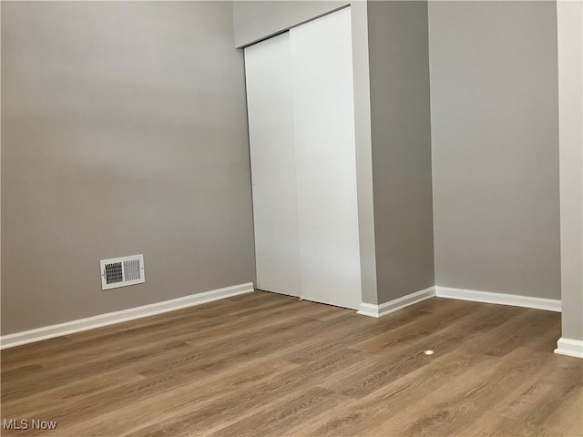 unfurnished bedroom with wood-type flooring and a closet