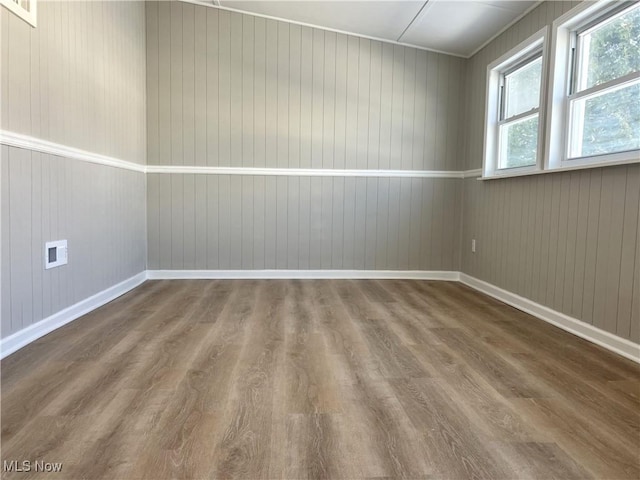 spare room featuring dark hardwood / wood-style flooring and wooden walls