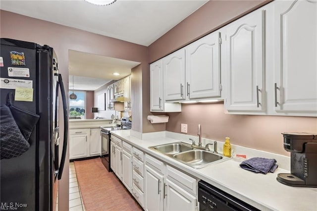 kitchen featuring white cabinets, light countertops, a sink, and black appliances