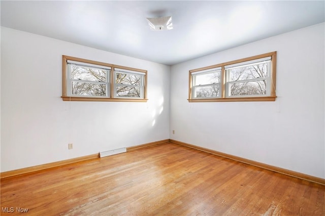 unfurnished room featuring a wealth of natural light and light hardwood / wood-style floors