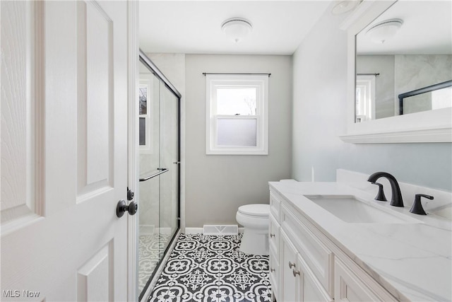 bathroom with vanity, toilet, tile patterned flooring, and a shower with door