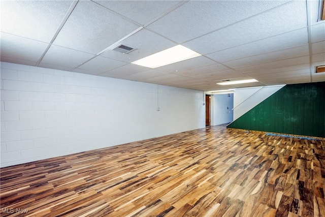 basement featuring wood-type flooring and a paneled ceiling