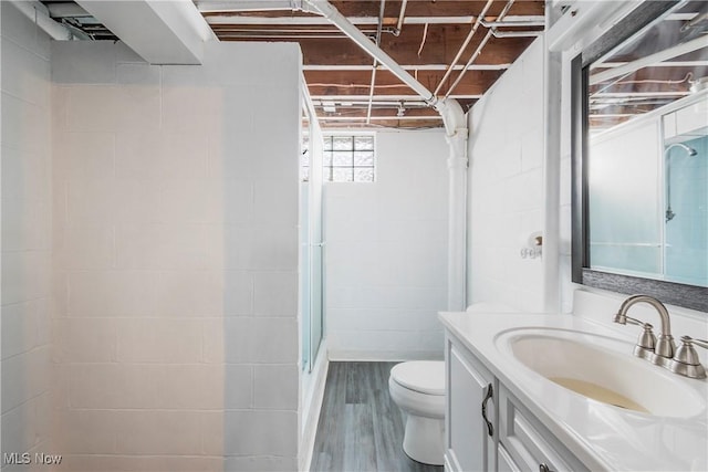 bathroom with toilet, vanity, wood-type flooring, and walk in shower