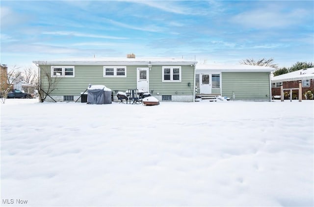 view of snow covered rear of property