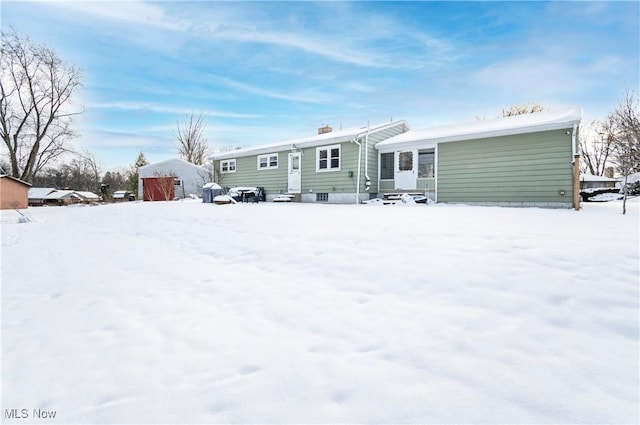 view of snow covered back of property