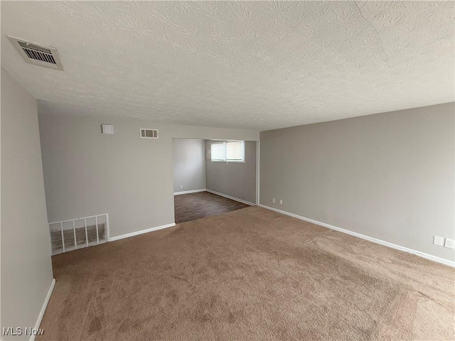 carpeted spare room with a textured ceiling