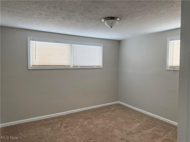 spare room featuring a textured ceiling and carpet flooring