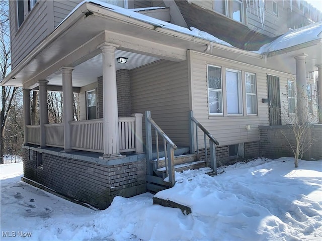 view of snow covered exterior featuring covered porch