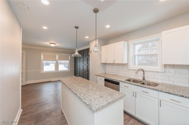 kitchen with white cabinets, a center island, sink, backsplash, and stainless steel dishwasher