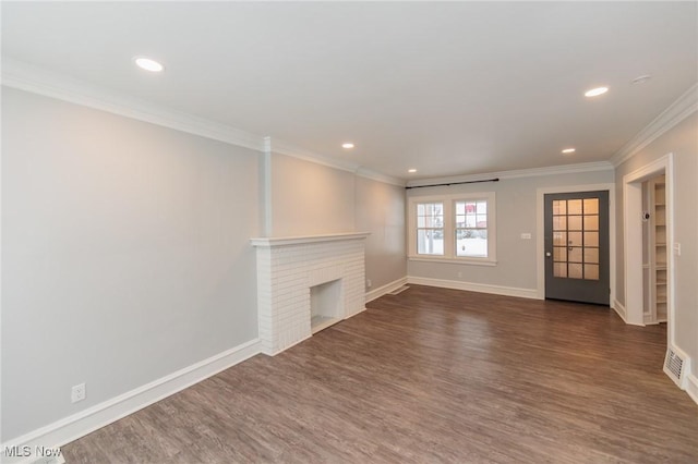 unfurnished living room with a brick fireplace, dark wood-type flooring, and crown molding