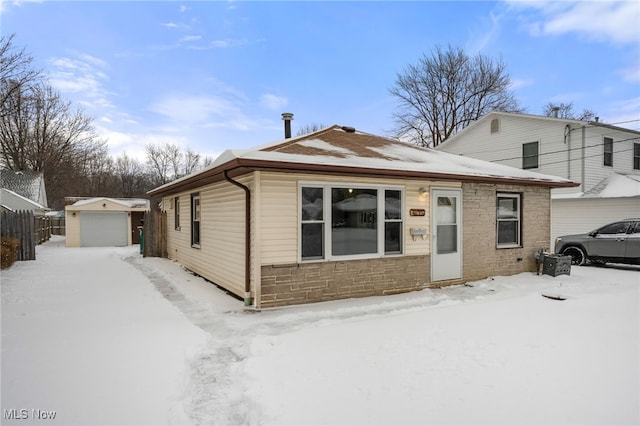 view of front of house with a garage and an outbuilding