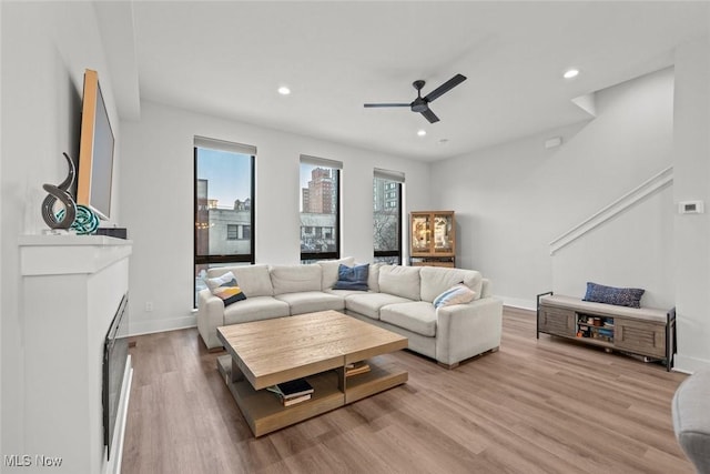 living room featuring ceiling fan and light hardwood / wood-style flooring