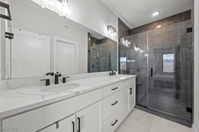 bathroom featuring a shower with door, vanity, and tile patterned flooring