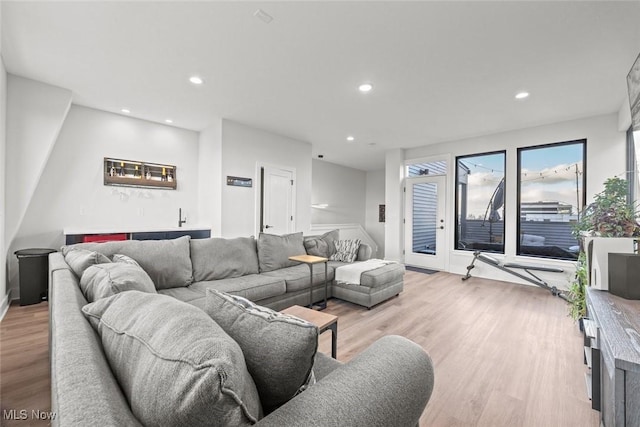 living room with bar and light wood-type flooring