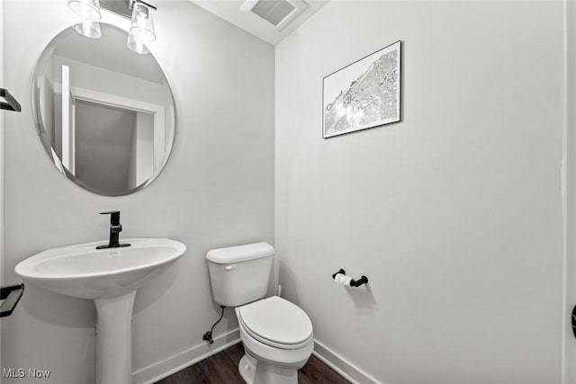 bathroom with hardwood / wood-style flooring, toilet, and sink