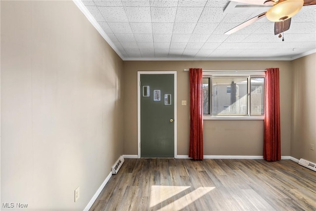 empty room featuring ceiling fan, hardwood / wood-style floors, and ornamental molding