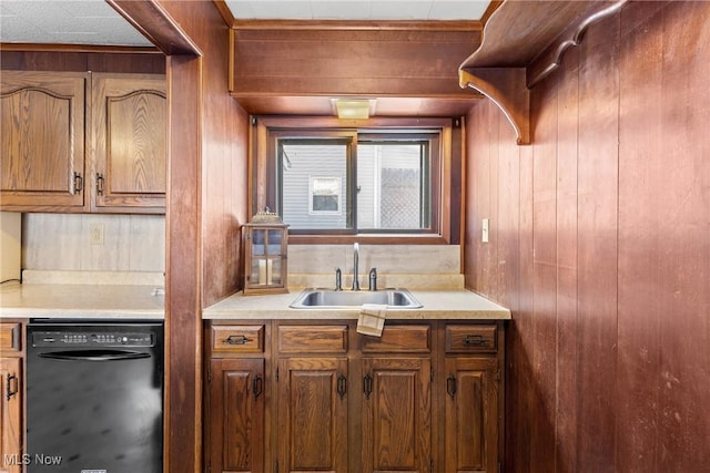 kitchen featuring sink, dishwasher, and wood walls