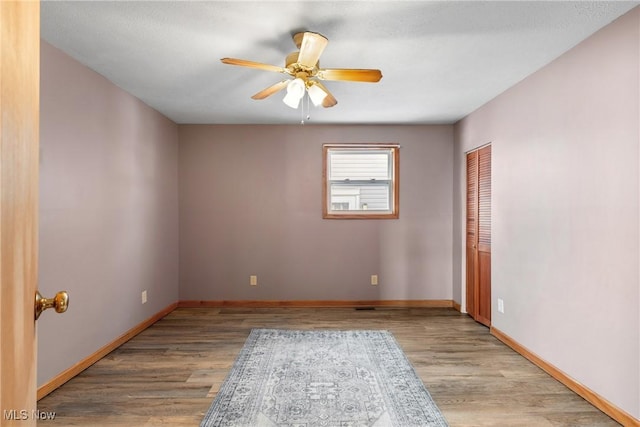 spare room with light wood-type flooring and ceiling fan