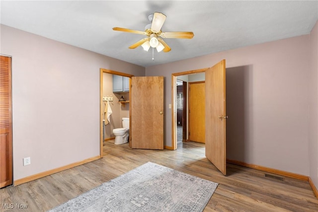 bedroom featuring ceiling fan, light hardwood / wood-style floors, a closet, and ensuite bath