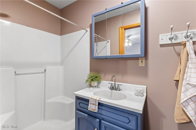 bathroom with ceiling fan, walk in shower, and vanity