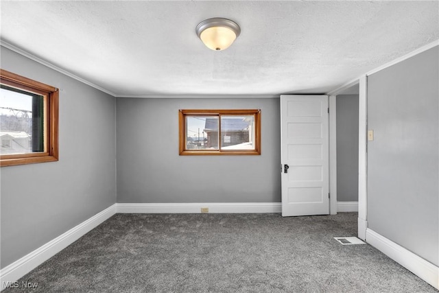 carpeted empty room with a textured ceiling