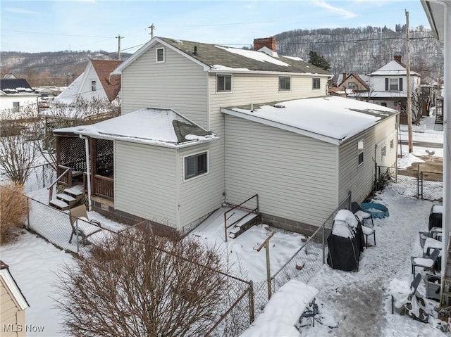 view of snow covered back of property