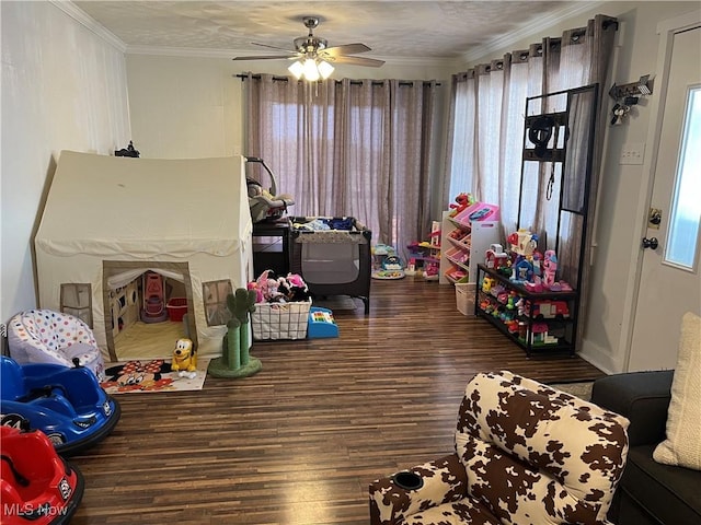 game room with ceiling fan, dark hardwood / wood-style floors, and crown molding