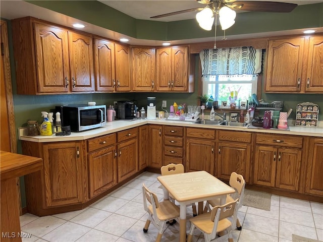 kitchen with ceiling fan, sink, and light tile patterned flooring