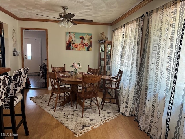 dining area featuring hardwood / wood-style flooring, ornamental molding, and ceiling fan