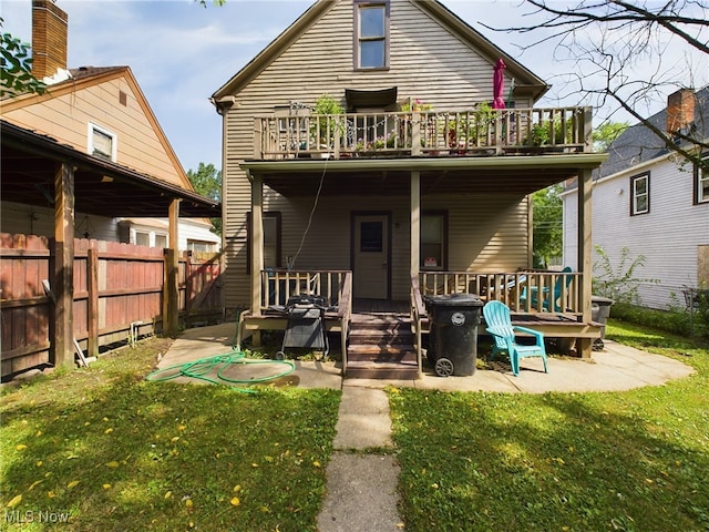 back of house featuring central AC unit, a deck, and a lawn