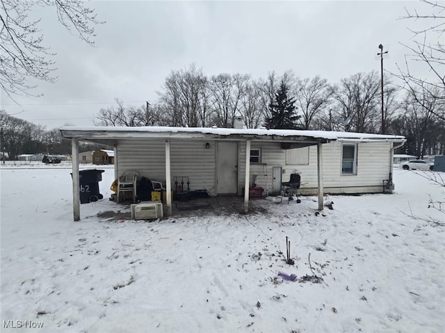 view of snow covered rear of property