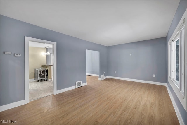 spare room featuring light hardwood / wood-style flooring and a notable chandelier