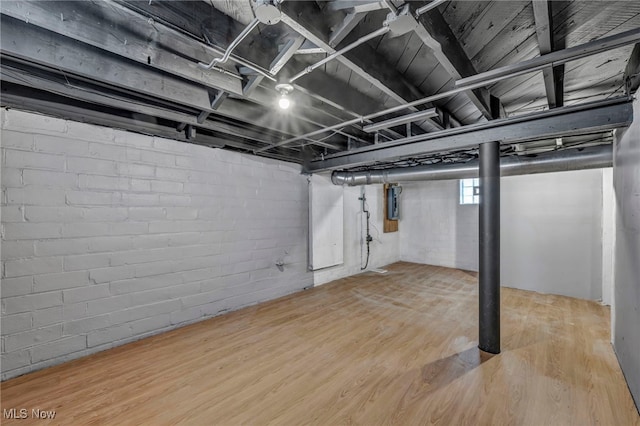 basement featuring hardwood / wood-style floors and electric panel