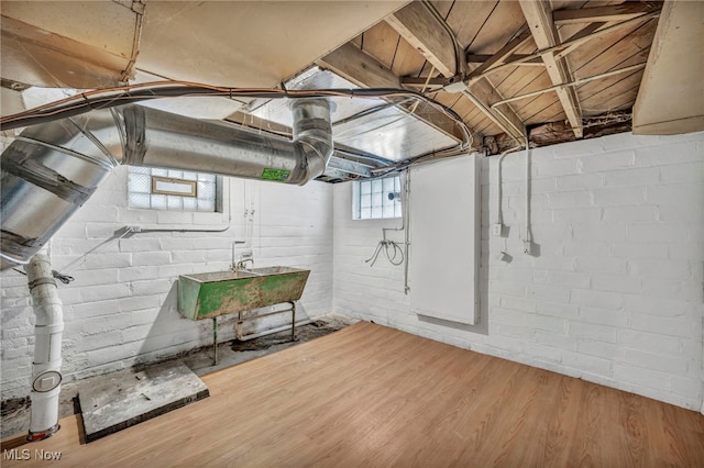 basement featuring hardwood / wood-style flooring and sink